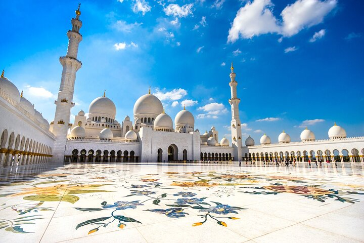 Marvel at the stunning architecture of the Grand Mosque where intricate designs and majestic domes create a breathtaking backdrop against a brilliant blue sky inviting exploration and wonder.